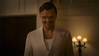 Ray Nicholson wearing a white suit creepily smiling in Smile 2